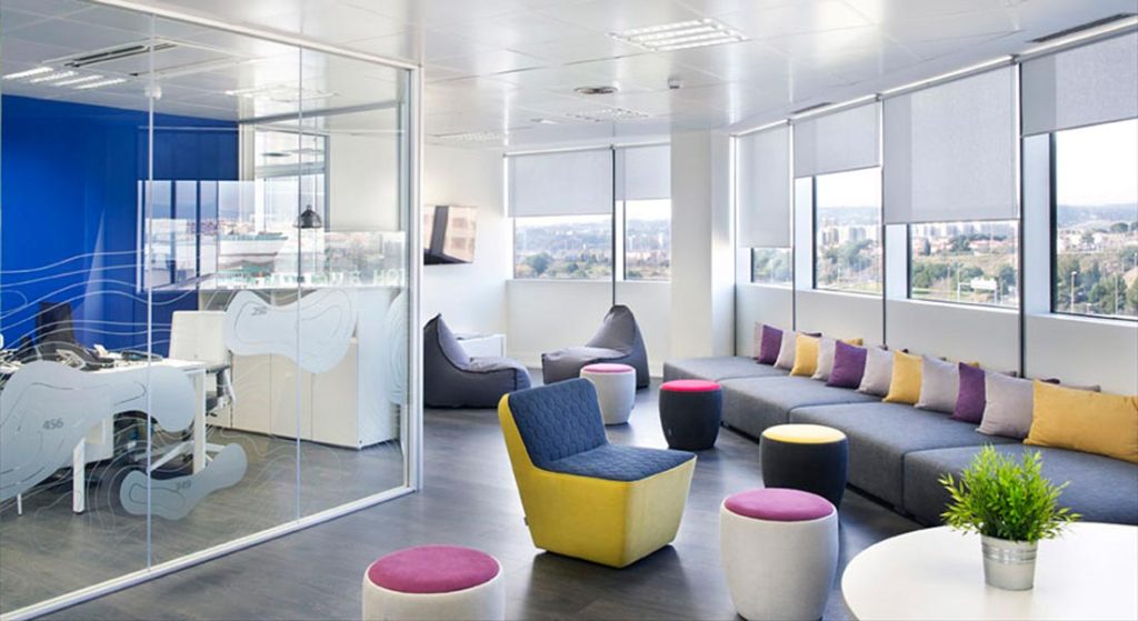 Diseño de smart office con zona de relax con soft seating y mamparas de vidrio